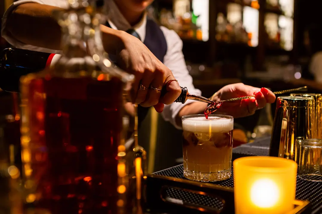 A bartender finishing a cocktail at Canoe’s bar