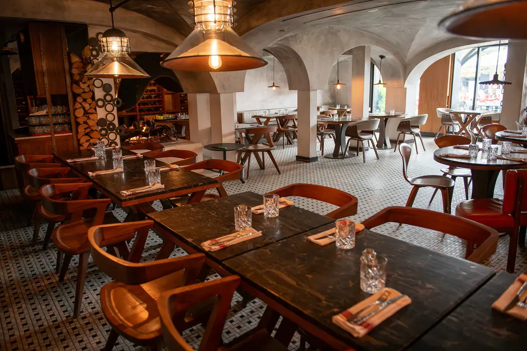 7 Enoteca’s vaulted dining room with red banquettes and warm pendant lights