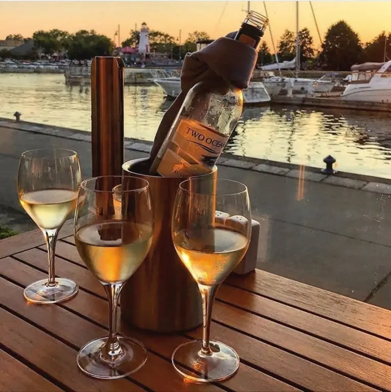 Glasses of white wine on the patio overlooking the boats at Snug Harbour