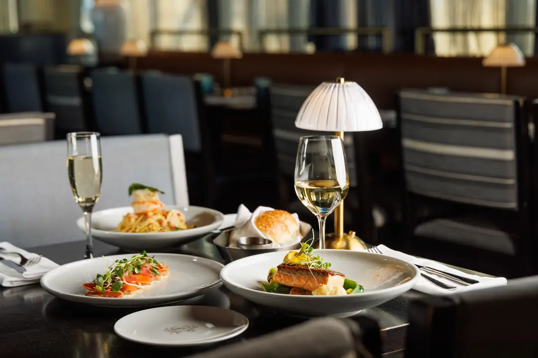 Plates of food and glasses of wine on a table at Spencer’s