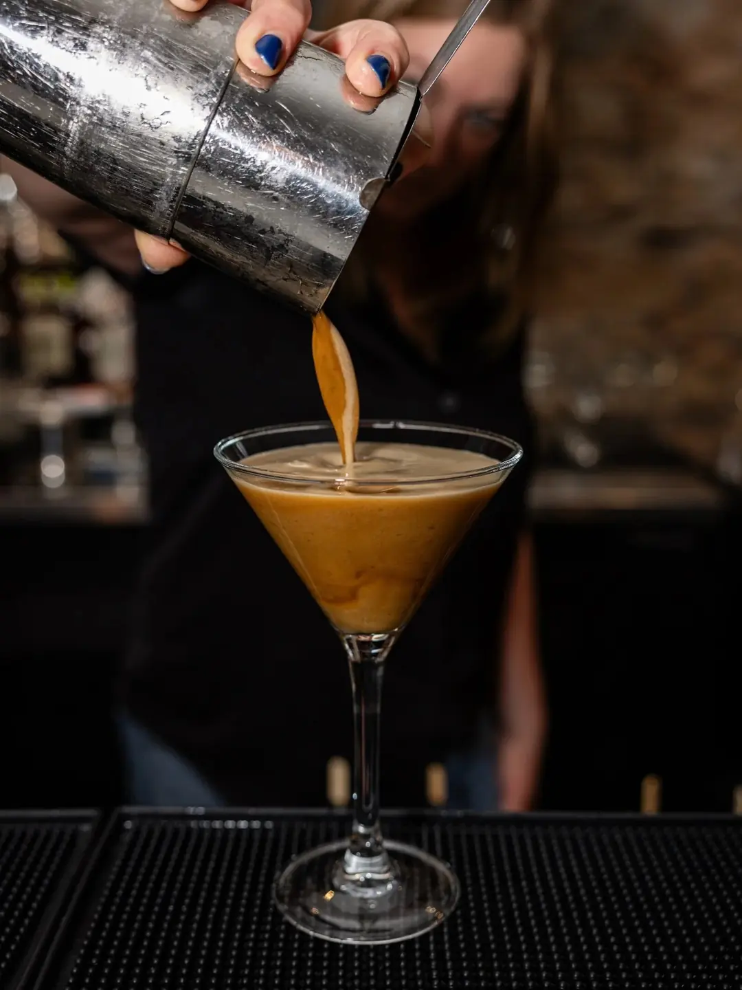 A cocktail being poured into a coupe at The French
