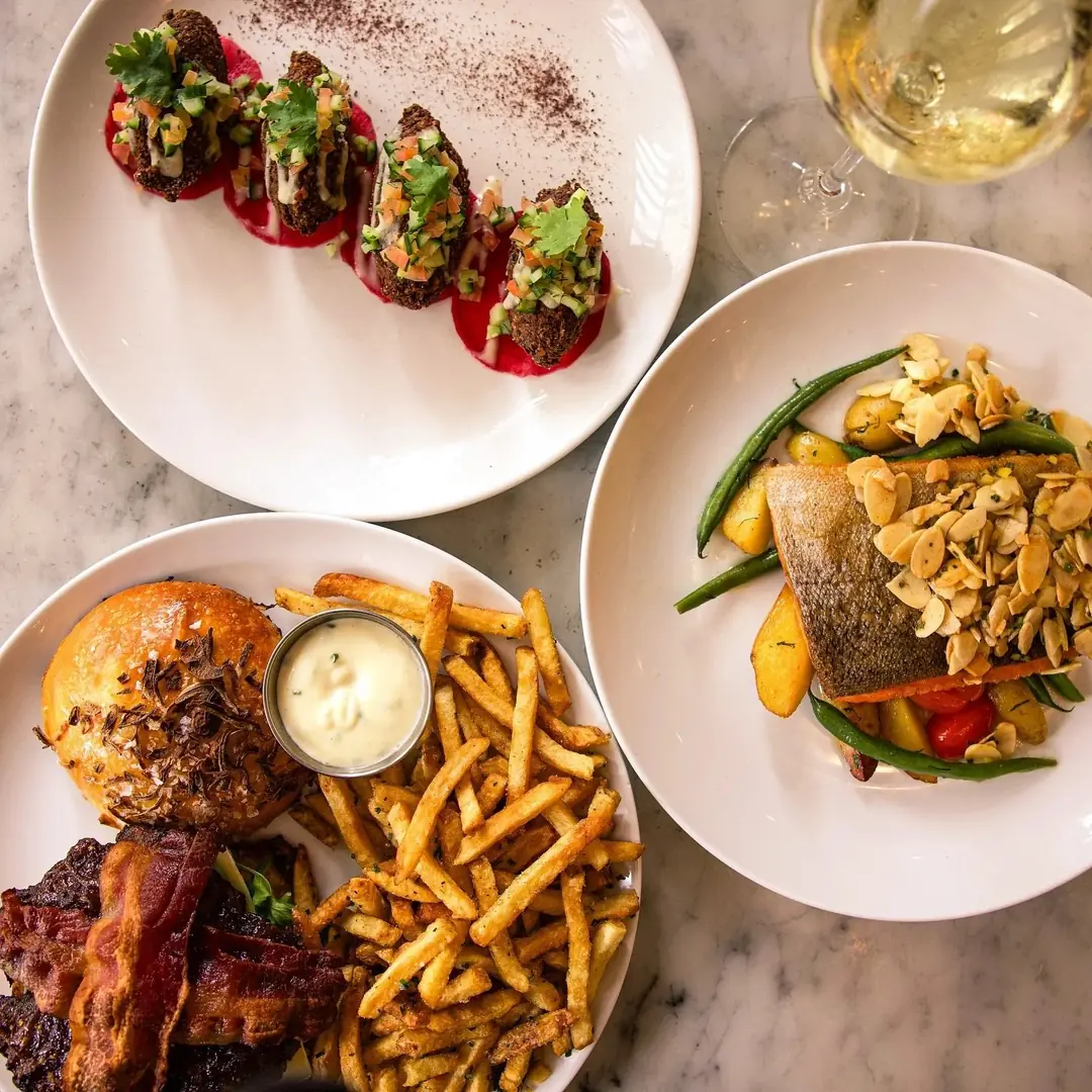 Steak frites and bistro plates on a table at The French in Hamilton
