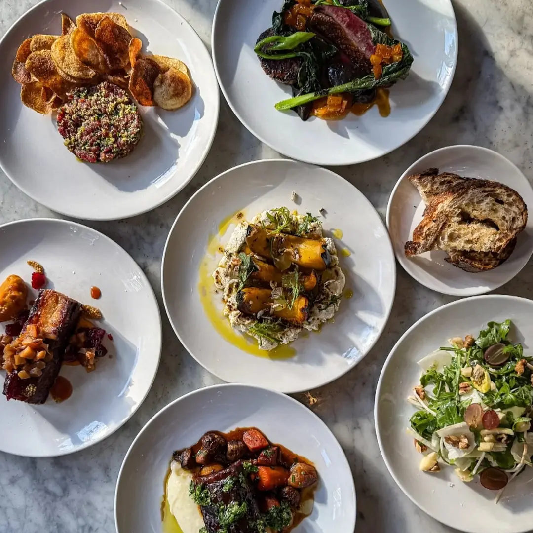 Shared plates and fresh bread on the table at The French