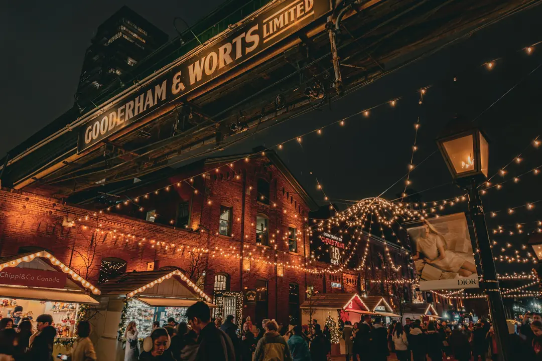 Crowds under string lights at the Christmas market in Toronto’s Distillery District
